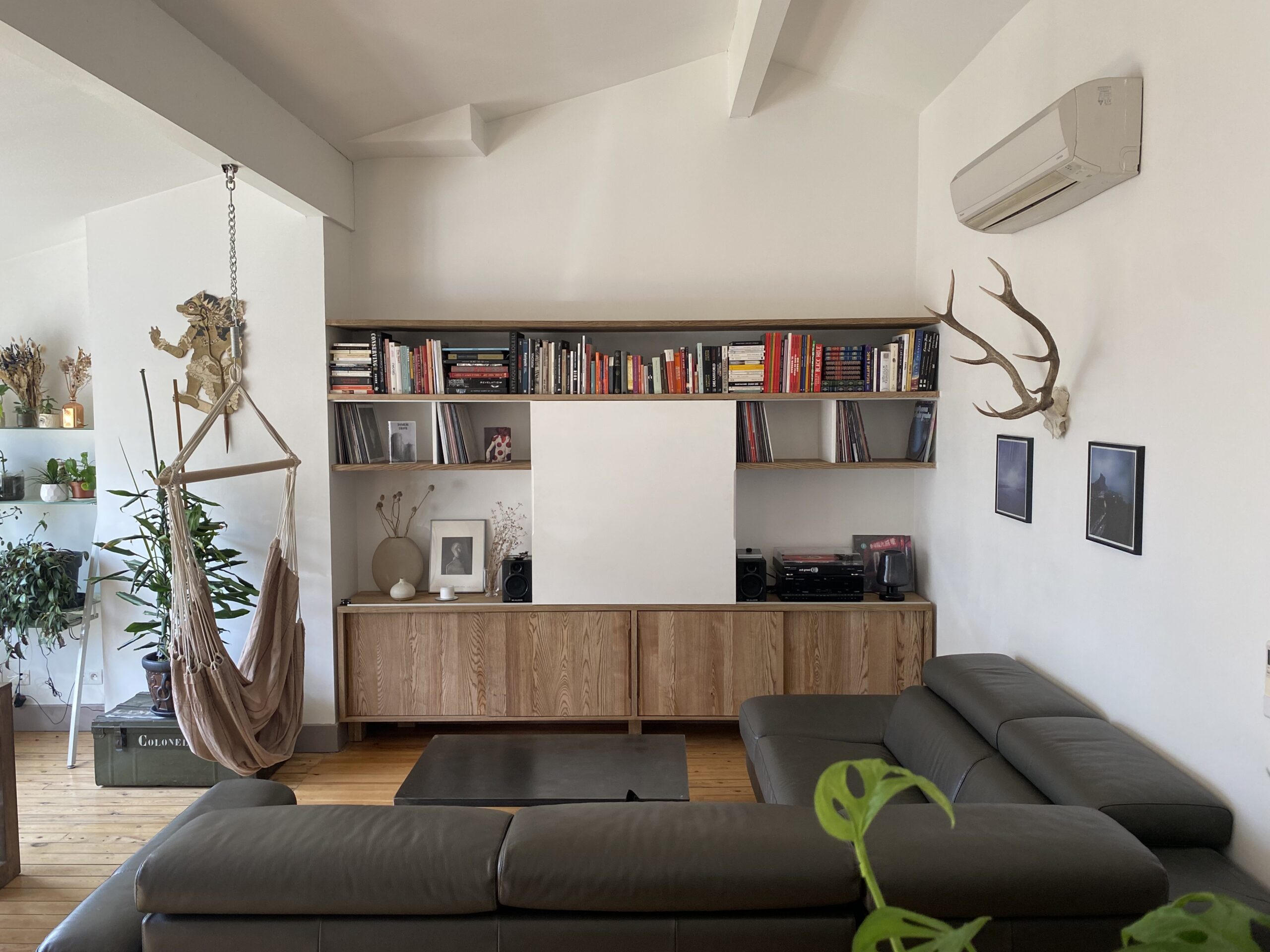 Aménagement intérieur, bibliothèque et console basse en frêne massif. Portes coulissantes, finition huilée. Fabrication sur mesure dans notre atelier d'ébénisterie.