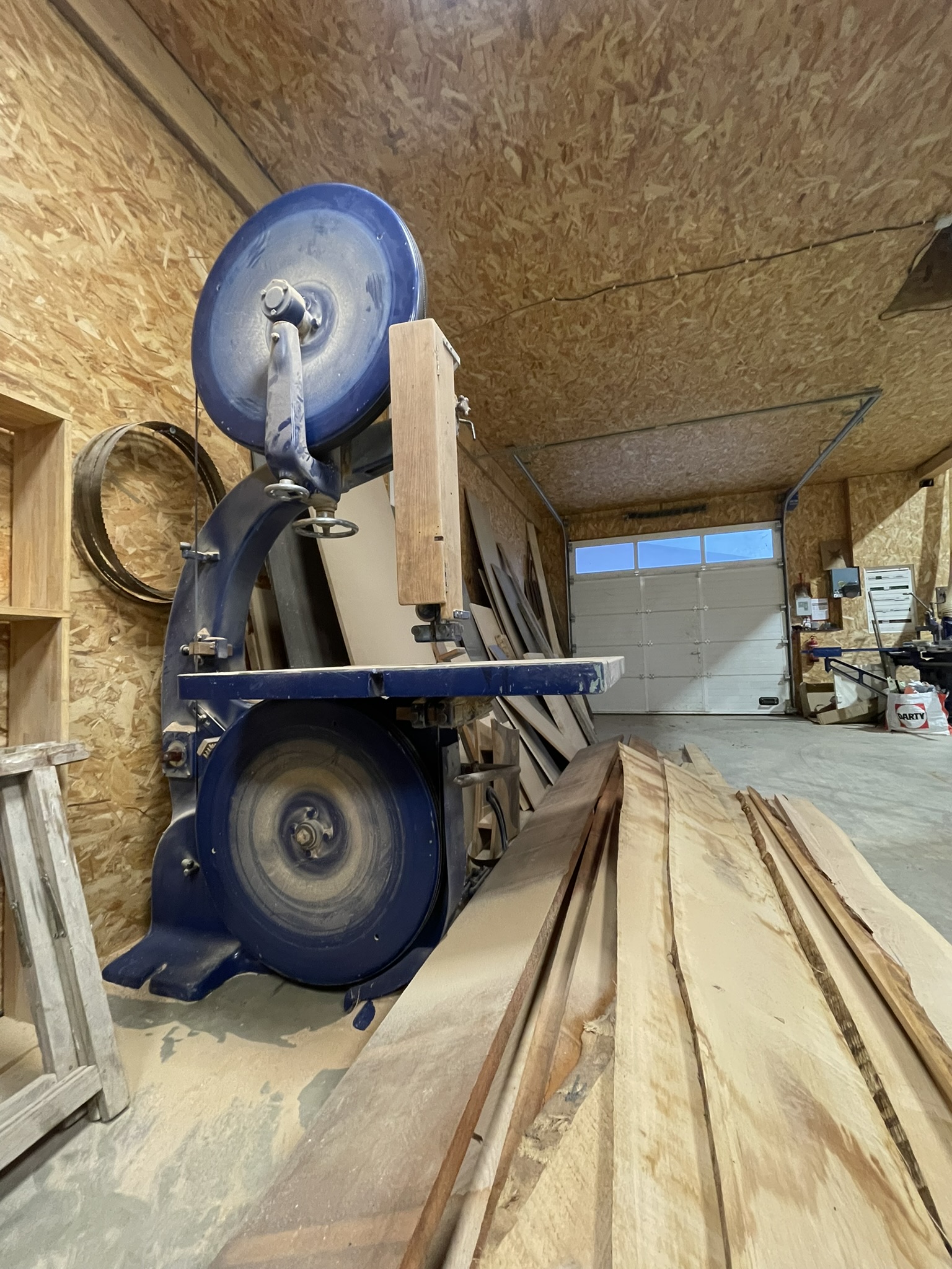 Scie à ruban professionnelle en atelier d'ébénisterie - Découpe précise du bois pour la fabrication sur mesure.